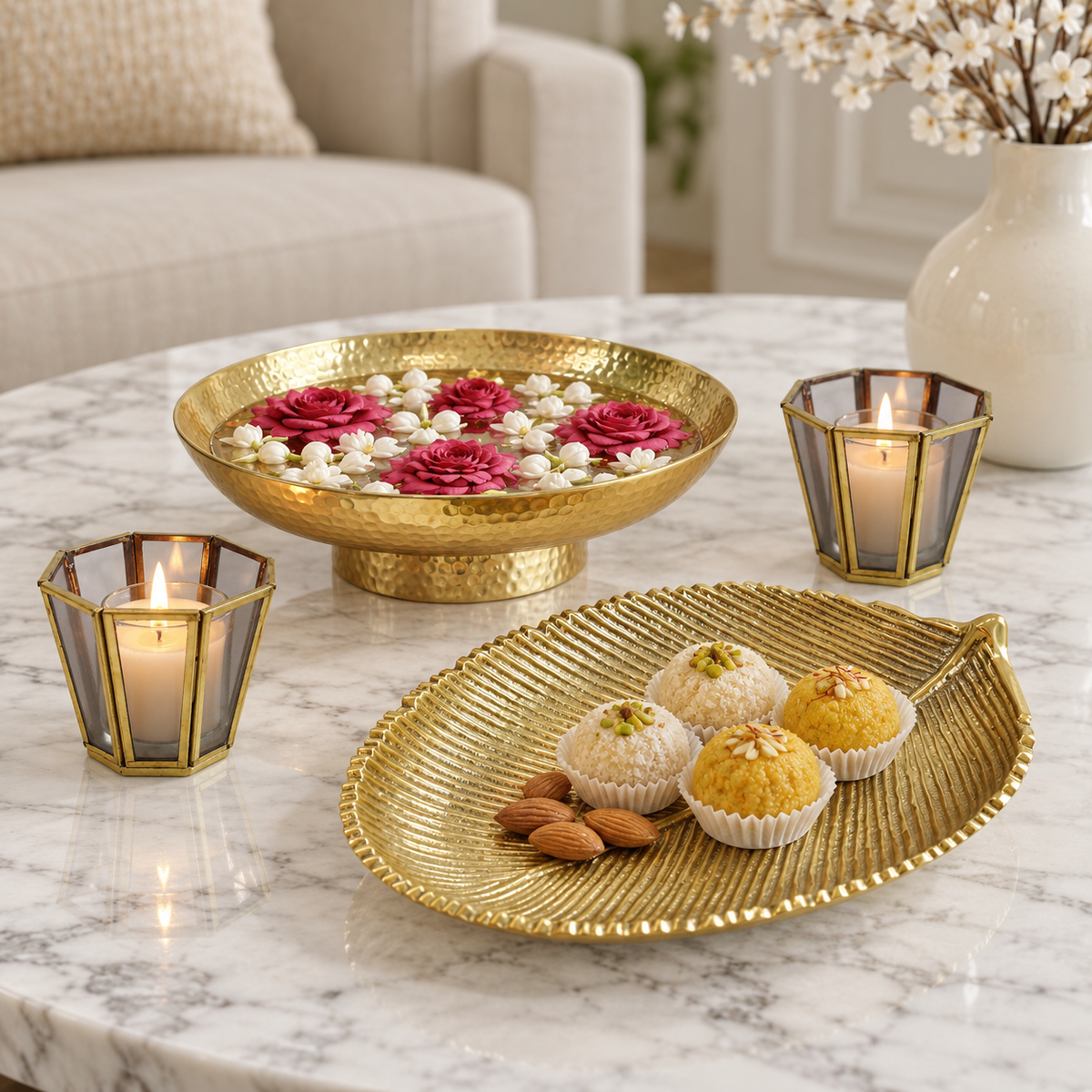 Kanchan hammered gold urli with large gold leaf platter and two grey glass votives, photographed on marble