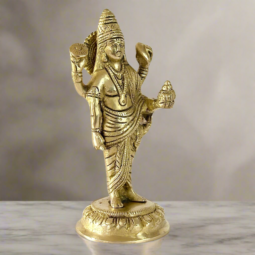 Product image of a Brass Dhanvantri Idol from Indian Impressions, showcasing Lord Dhanvantri in a standing posture holding sacred items. The idol is intricately crafted with fine details and features a polished brass finish, ideal for Vastu, spiritual practices, home décor, or gifting to promote health and well-being.