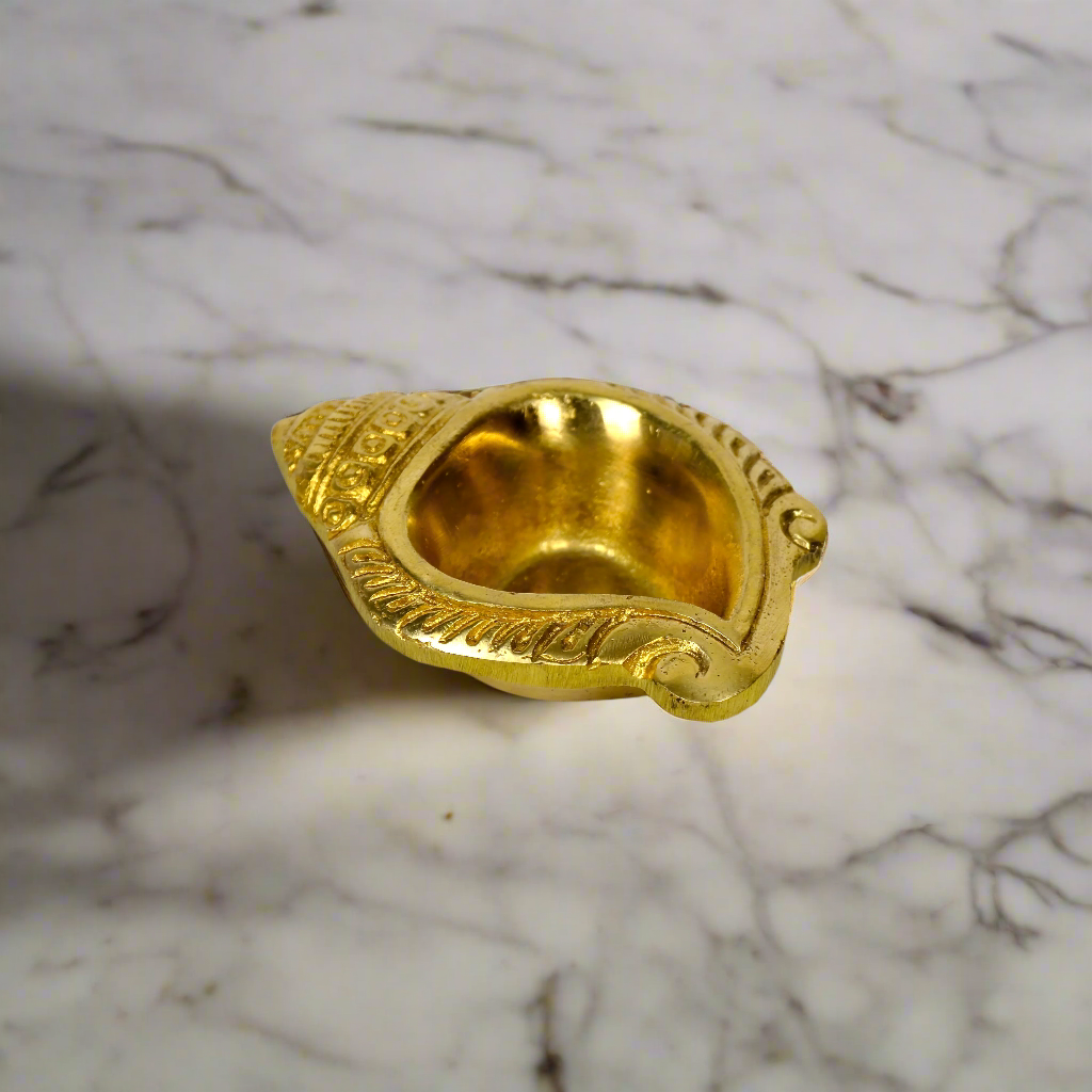 Product image of a Brass Shankh Diya from Indian Impressions, featuring a beautifully crafted conch shell design with intricate detailing. Made from polished brass, this diya is perfect for Vastu, spiritual rituals, home décor, or gifting, symbolizing purity, positivity, and divine energy.