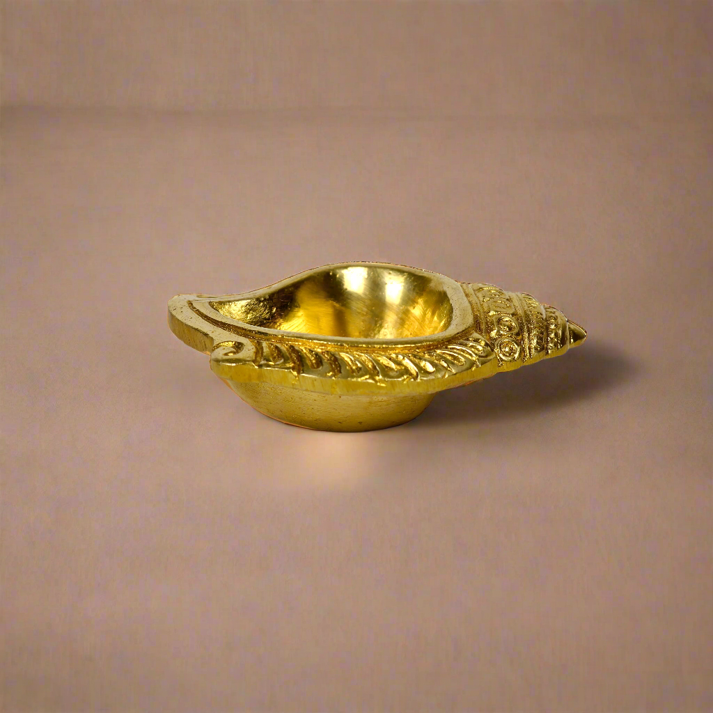 Product image of a Brass Shankh Diya from Indian Impressions, featuring a beautifully crafted conch shell design with intricate detailing. Made from polished brass, this diya is perfect for Vastu, spiritual rituals, home décor, or gifting, symbolizing purity, positivity, and divine energy.