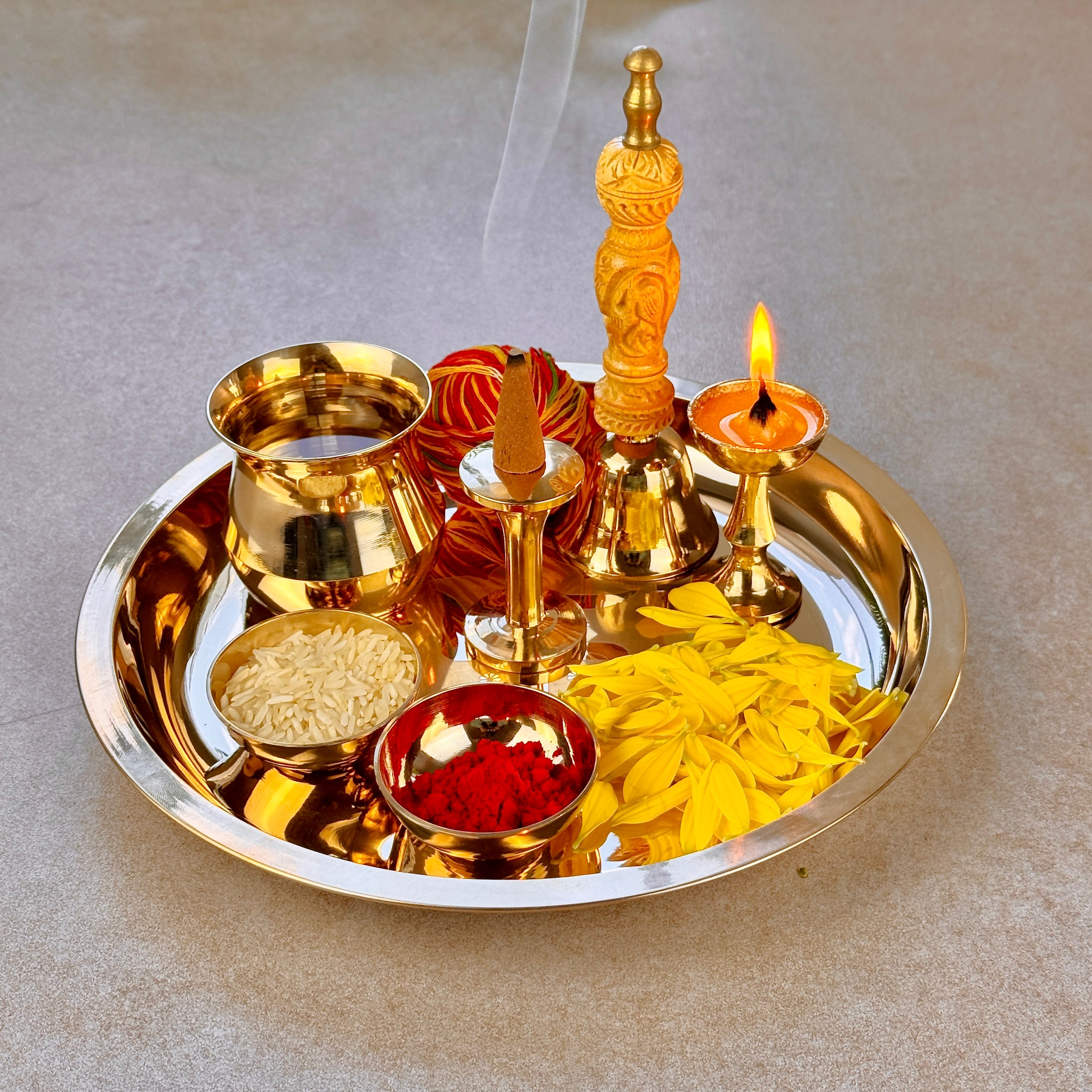 Product image of a Bronze Pooja Thali Set from Indian Impressions, featuring a beautifully handcrafted design. The set includes a thali, diya, incense holder, and small bowls, all crafted from polished bronze. Perfect for Vastu, spiritual rituals, home décor, or gifting, it adds a traditional and elegant touch to any sacred space.