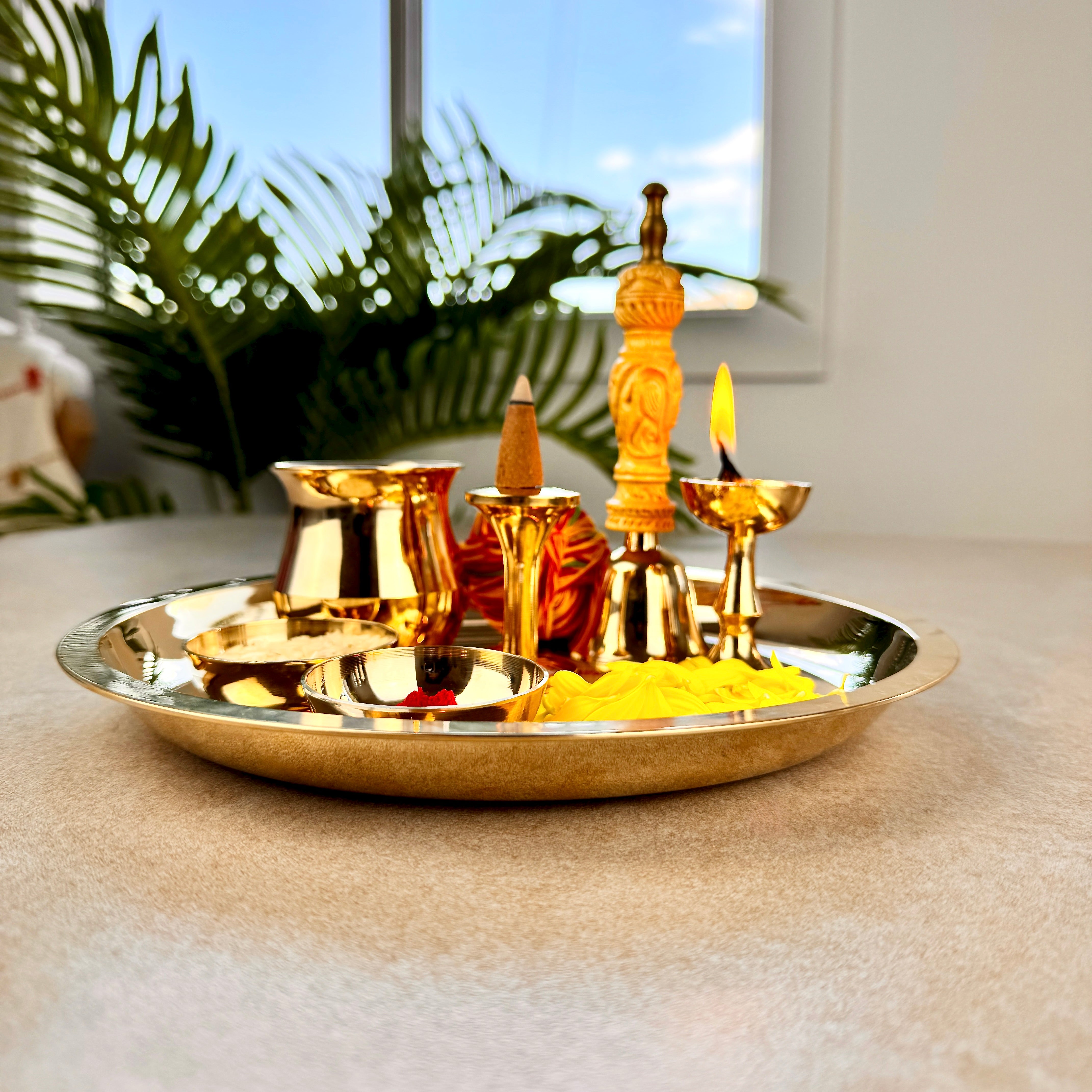 Product image of a Bronze Pooja Thali Set from Indian Impressions, featuring a beautifully handcrafted design. The set includes a thali, diya, incense holder, and small bowls, all crafted from polished bronze. Perfect for Vastu, spiritual rituals, home décor, or gifting, it adds a traditional and elegant touch to any sacred space.