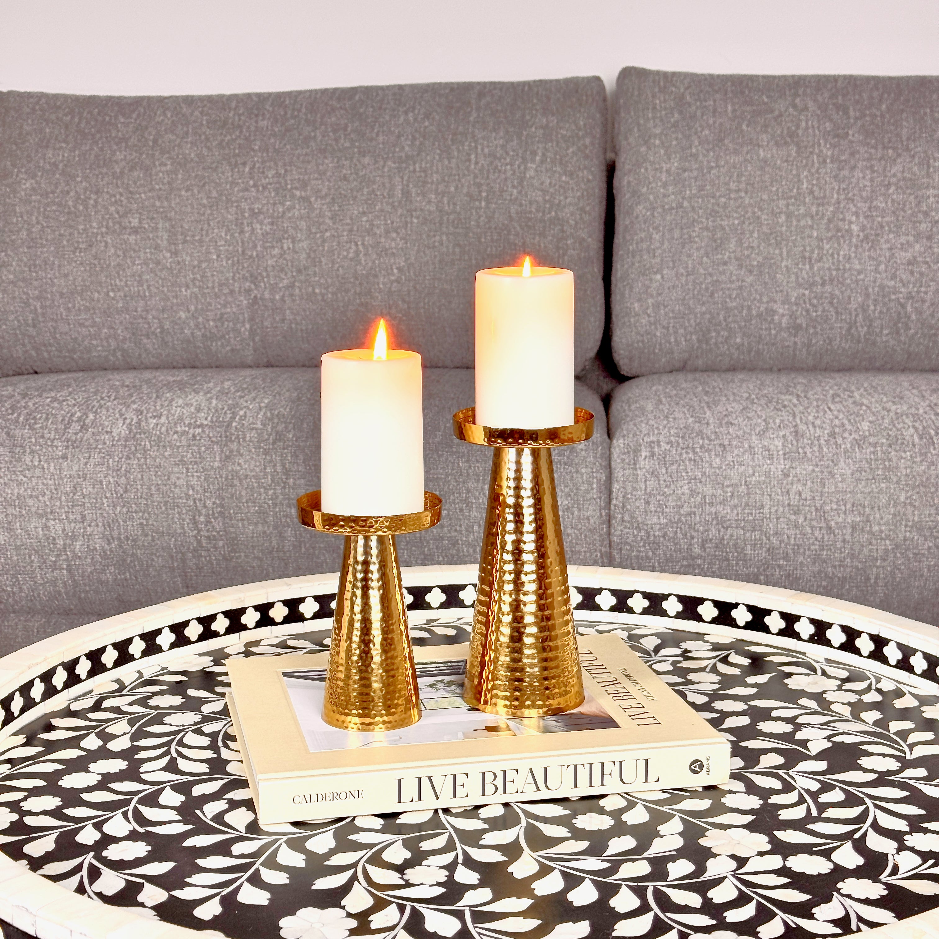 Product image of a Metal Candle Holder Set of 2 from Indian Impressions, featuring elegantly crafted holders with a Hammered finish. Designed for pillar or taper candles, these holders add a touch of sophistication to any setting. Perfect for Vastu, home décor, festive occasions, or gifting.