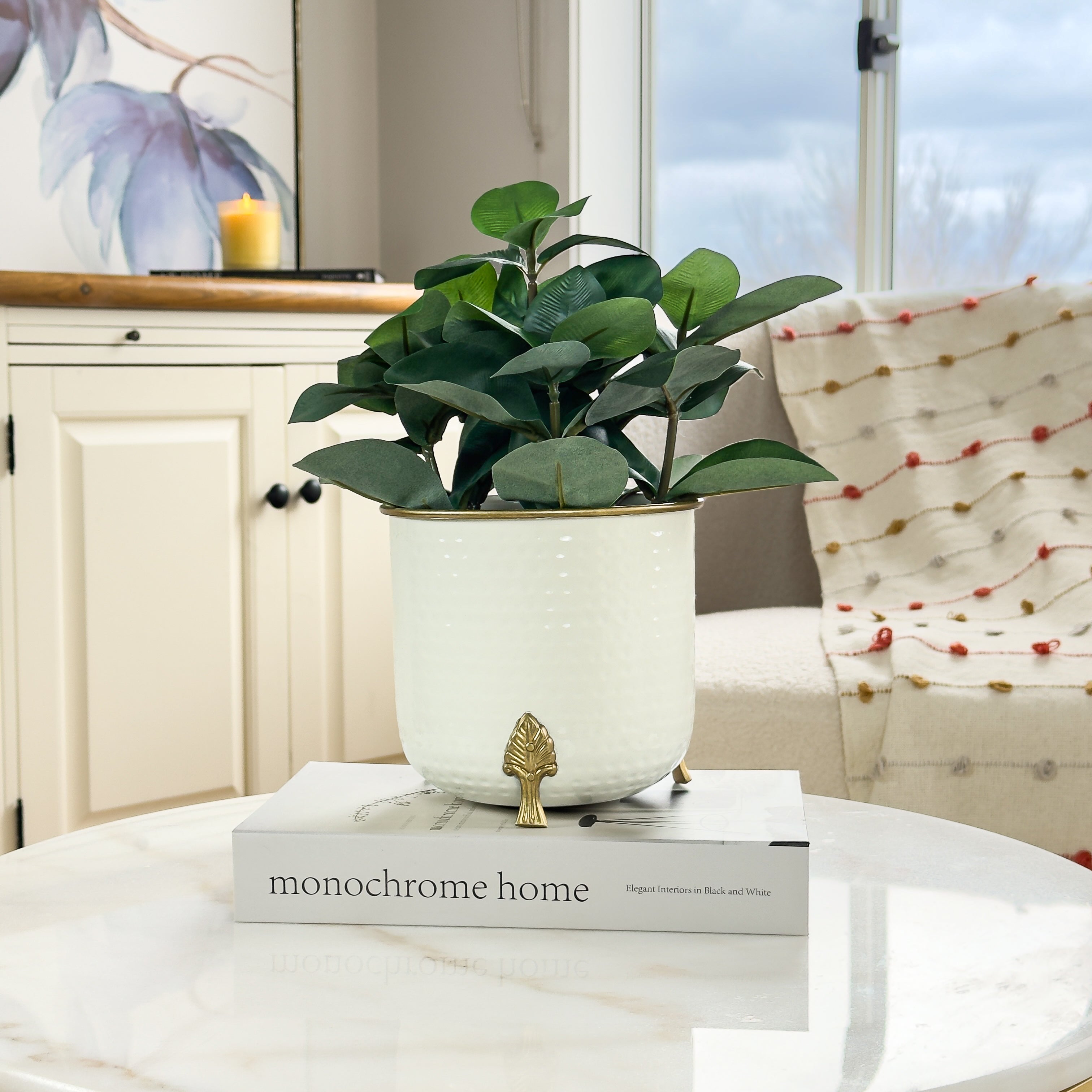 Product image of a Metal Hammered Gold Rim Leaf Leg Planter in White from Indian Impressions, featuring a sleek white body with a hammered texture and a gold rim for an elegant finish. Supported by sturdy leaf-patterned legs, this planter is ideal for enhancing Vastu energy, modern home décor, or gifting, adding sophistication to any space.