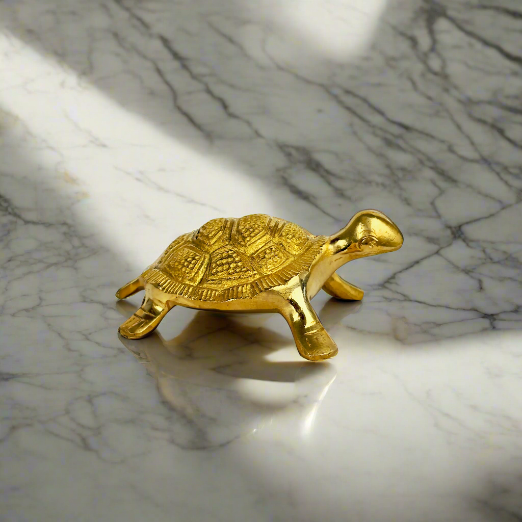 Gold turtle figurine on a marble surface