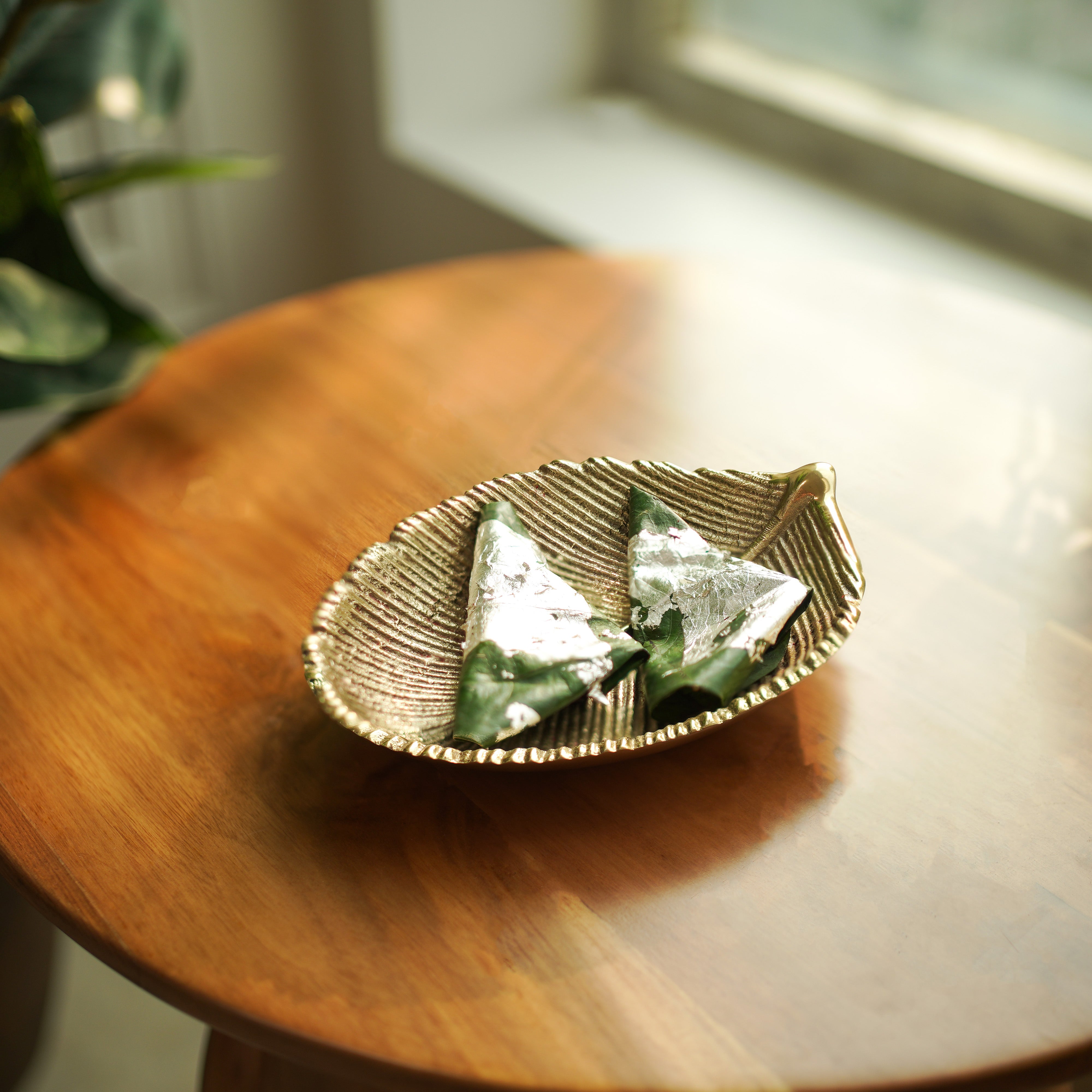 Decorative leaf-shaped dish with Paan on a wooden surface