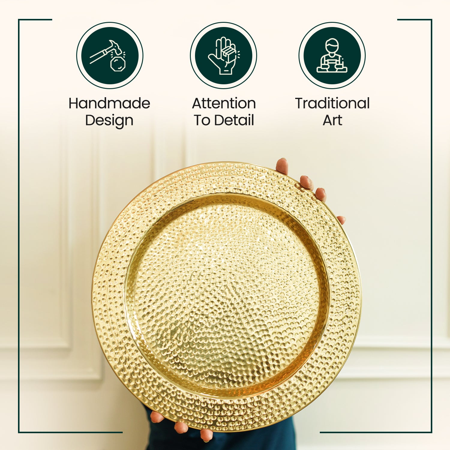 Gold decorative plate held by a hand with icons indicating 'Handmade Design', 'Attention To Detail', and 'Traditional Art' on a light background.