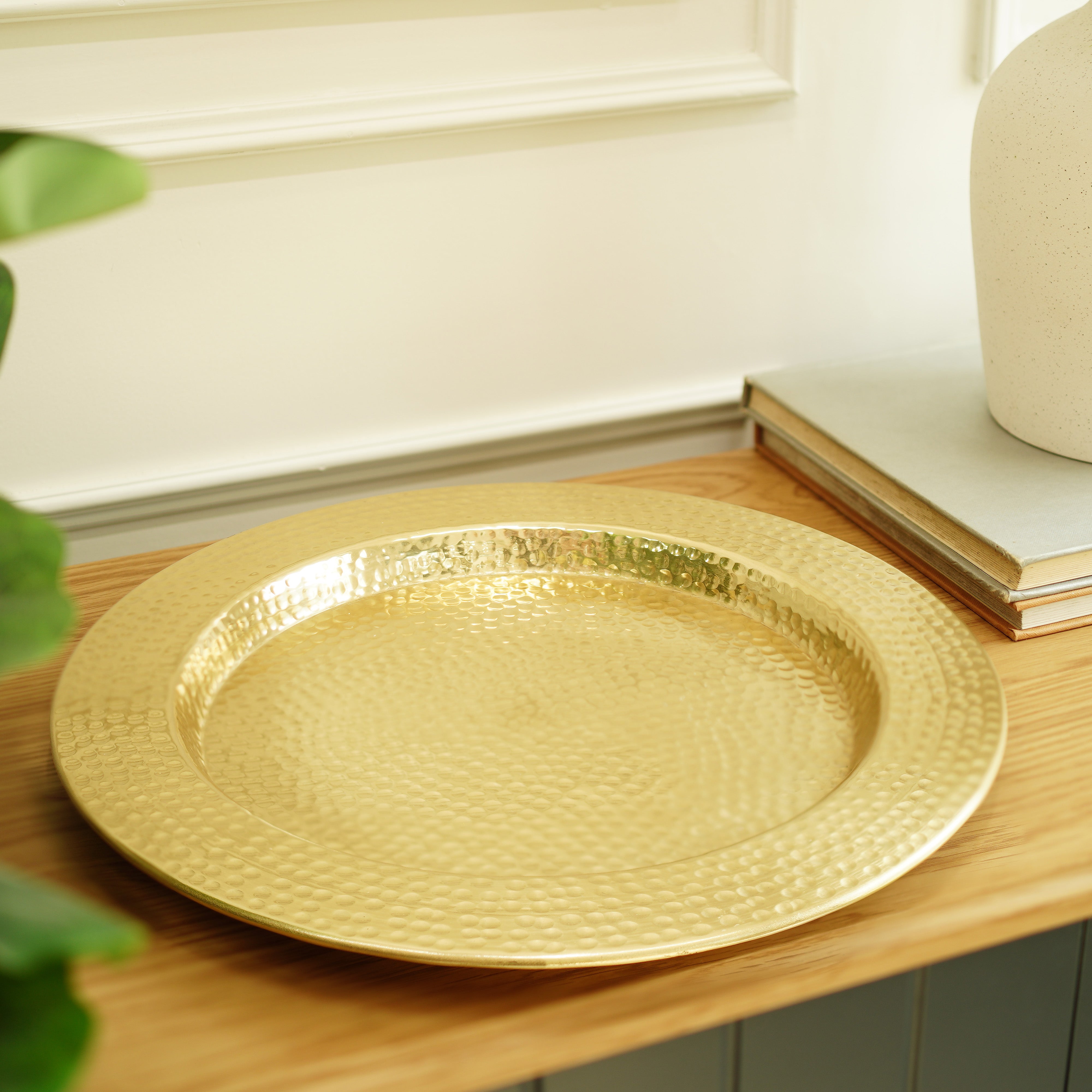Gold decorative plate on a wooden surface with a neutral background