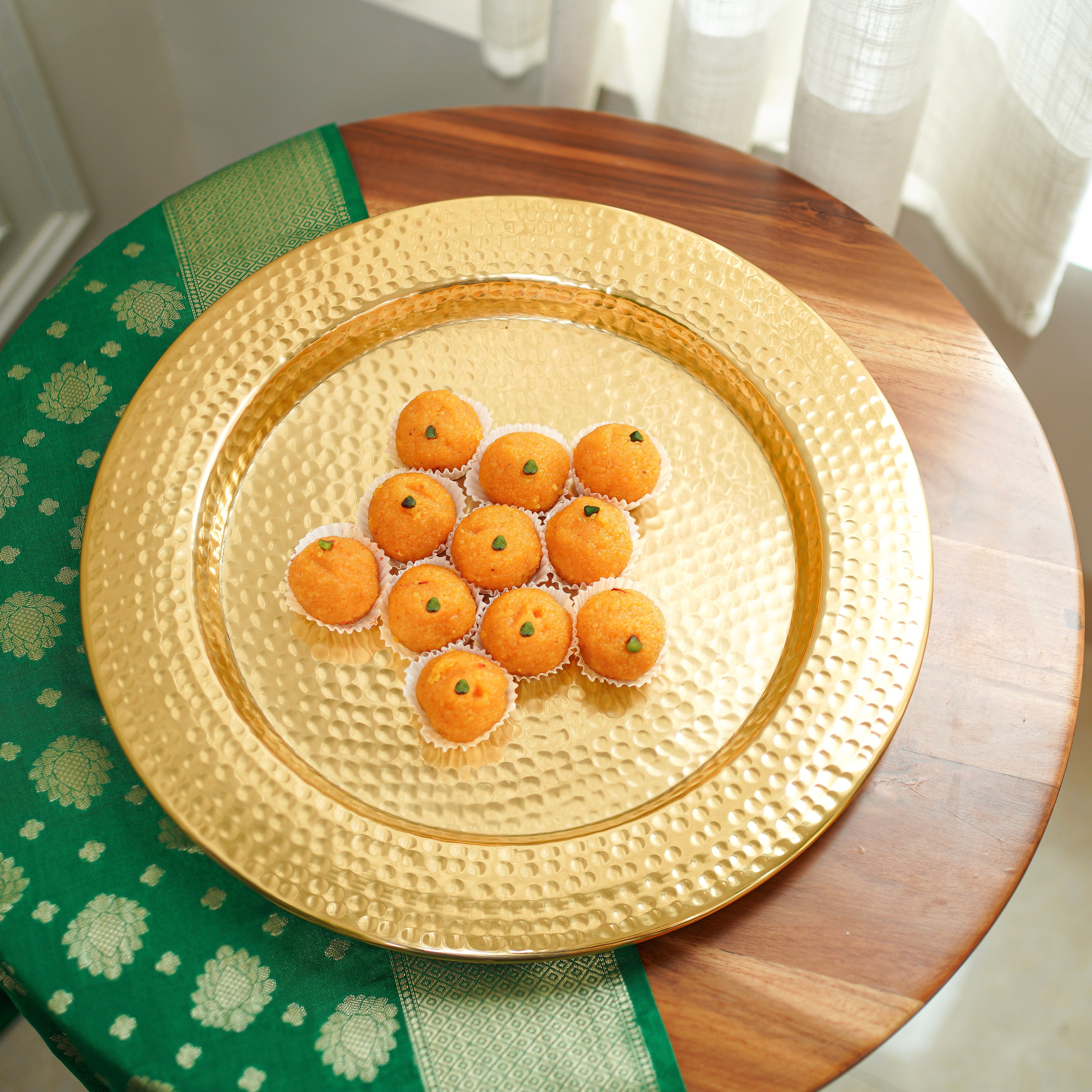 Gold decorative plate with small round items on a wooden table