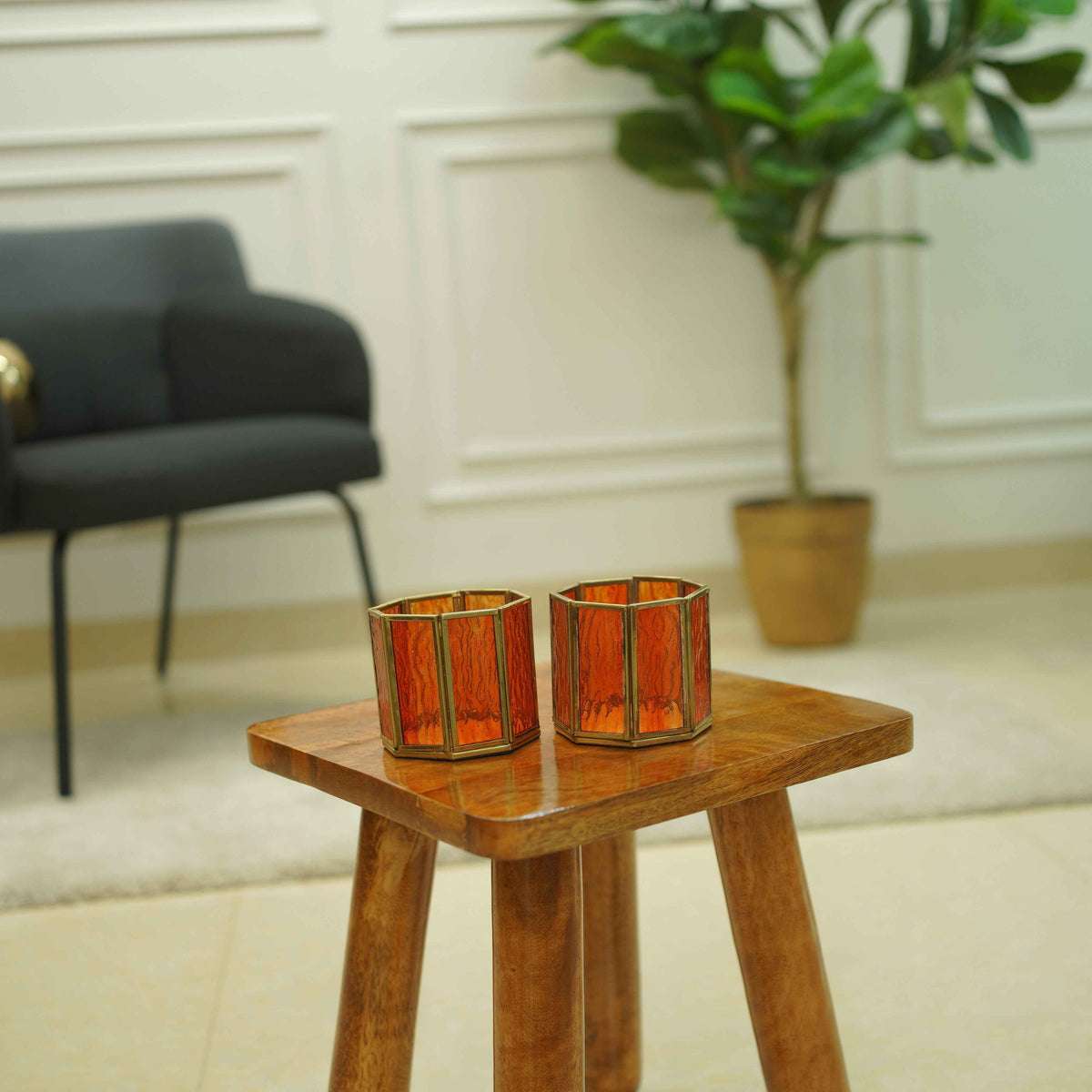 Orange glass votive holders styled as a pair for a festive table