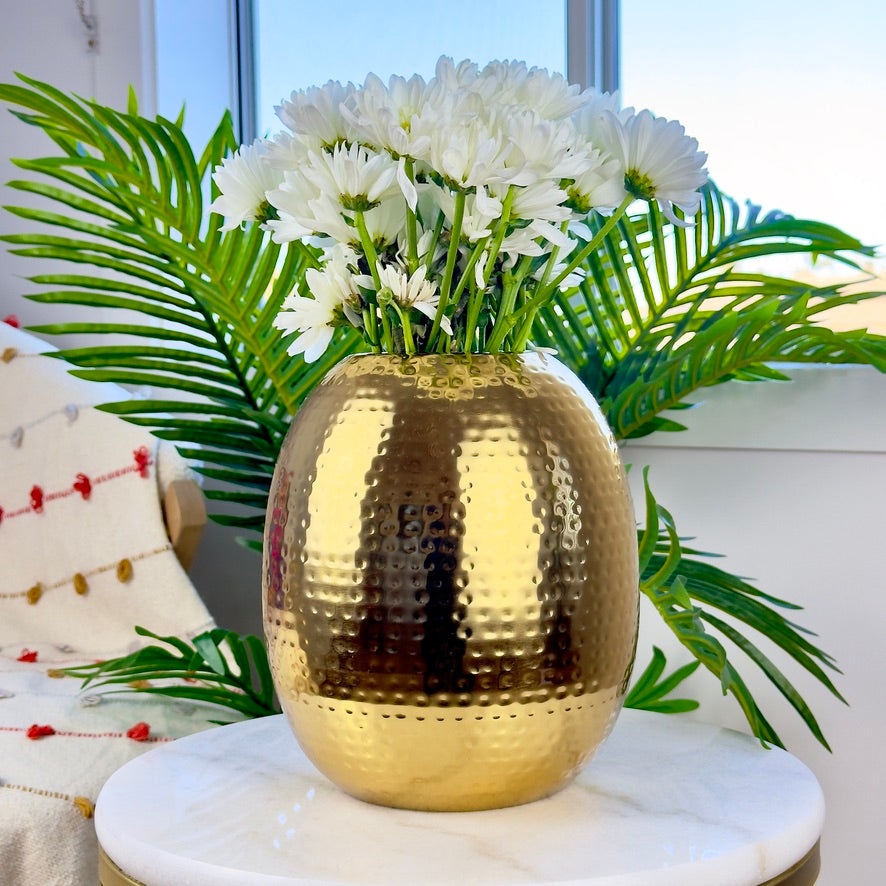 Product image of the Oval Vase Hammered Gold from Indian Impressions, featuring a sleek oval design with a textured hammered finish. Crafted with a polished gold-tone, this vase is perfect for displaying flowers or as a standalone décor piece. Ideal for Vastu, home décor, or gifting, adding elegance and sophistication to any space.