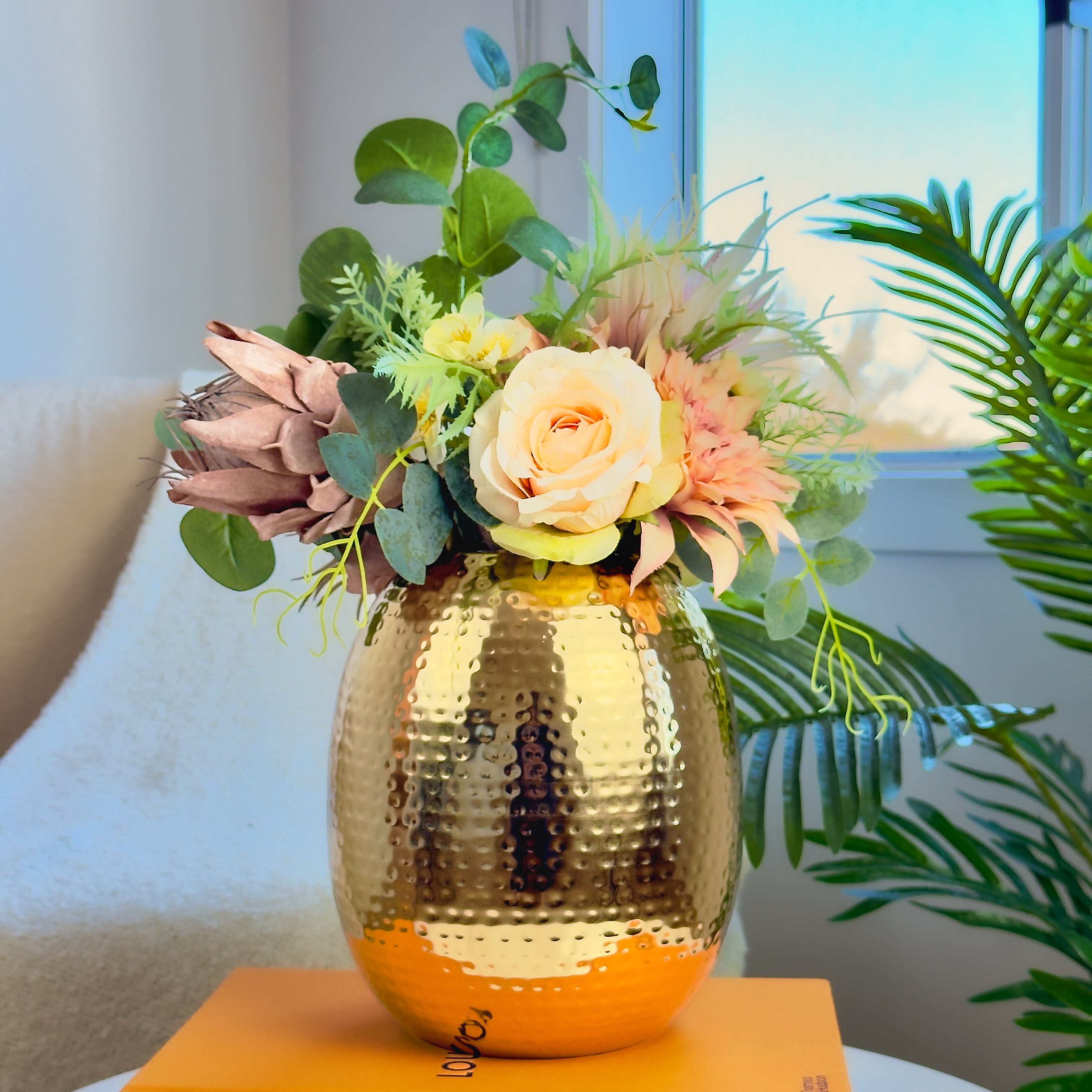 Product image of the Oval Vase Hammered Gold from Indian Impressions, featuring a sleek oval design with a textured hammered finish. Crafted with a polished gold-tone, this vase is perfect for displaying flowers or as a standalone décor piece. Ideal for Vastu, home décor, or gifting, adding elegance and sophistication to any space.