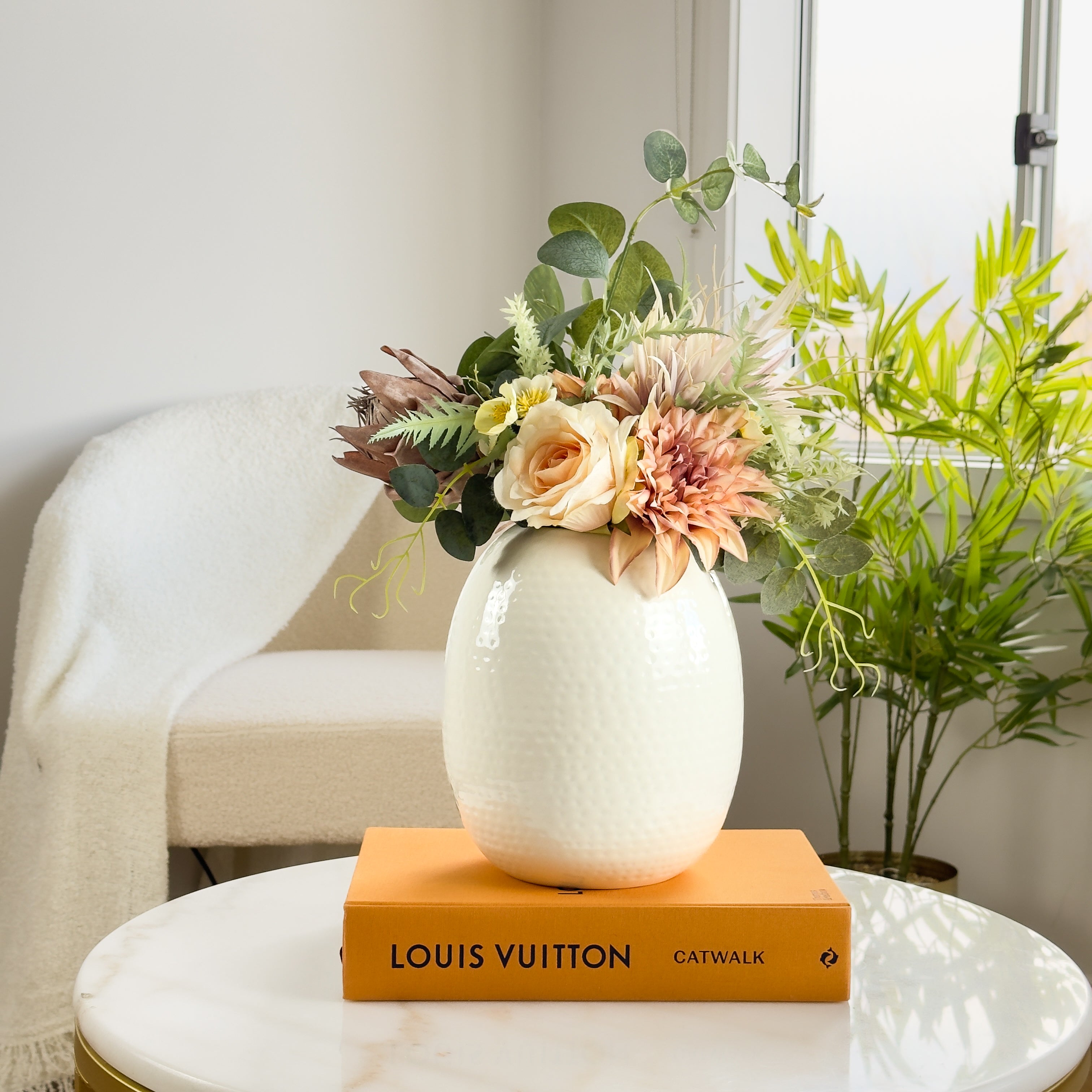 Product image of the Oval Vase Hammered White from Indian Impressions, featuring a sleek oval shape with a textured hammered finish. Designed with a polished white tone, this vase is ideal for displaying flowers or as a standalone décor piece. Perfect for Vastu, home décor, or gifting, bringing a modern and elegant touch to any space.