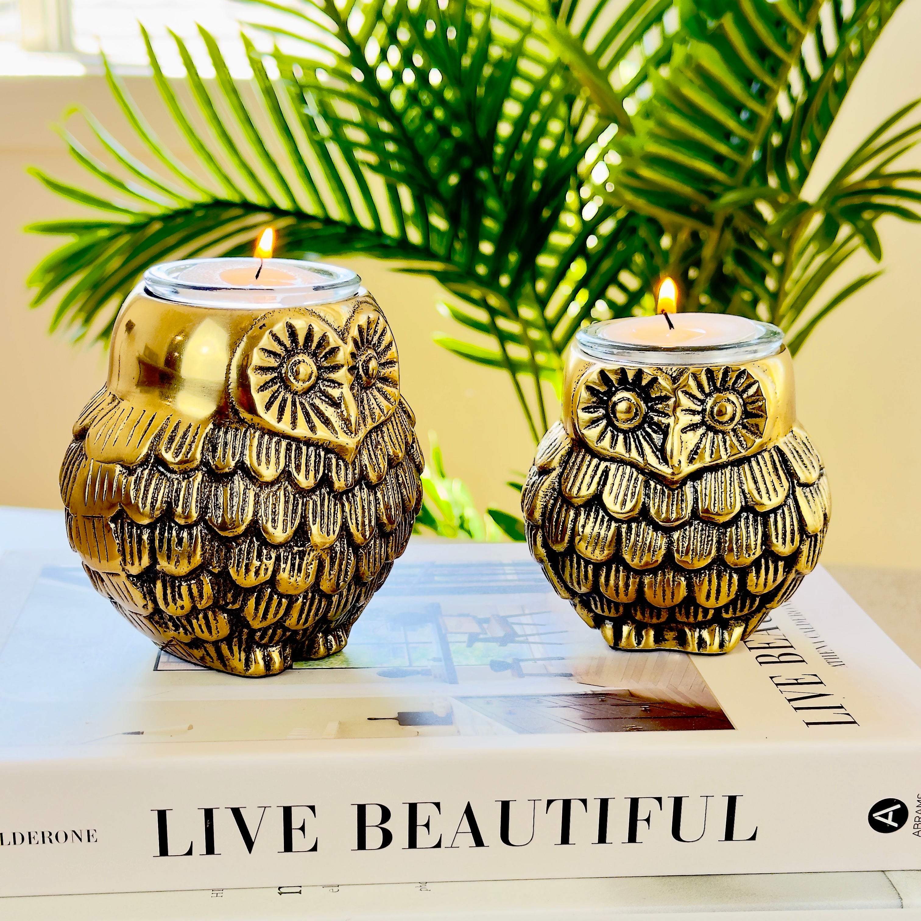 Product image of the Owl Figurine Pair Tea light Holder with Antique Brass Finish from Indian Impressions, featuring two intricately designed owl statues with detailed craftsmanship. Symbolizing wisdom and protection, these figurines are ideal for Vastu, home décor, or gifting, adding a touch of charm and positive energy to any space.