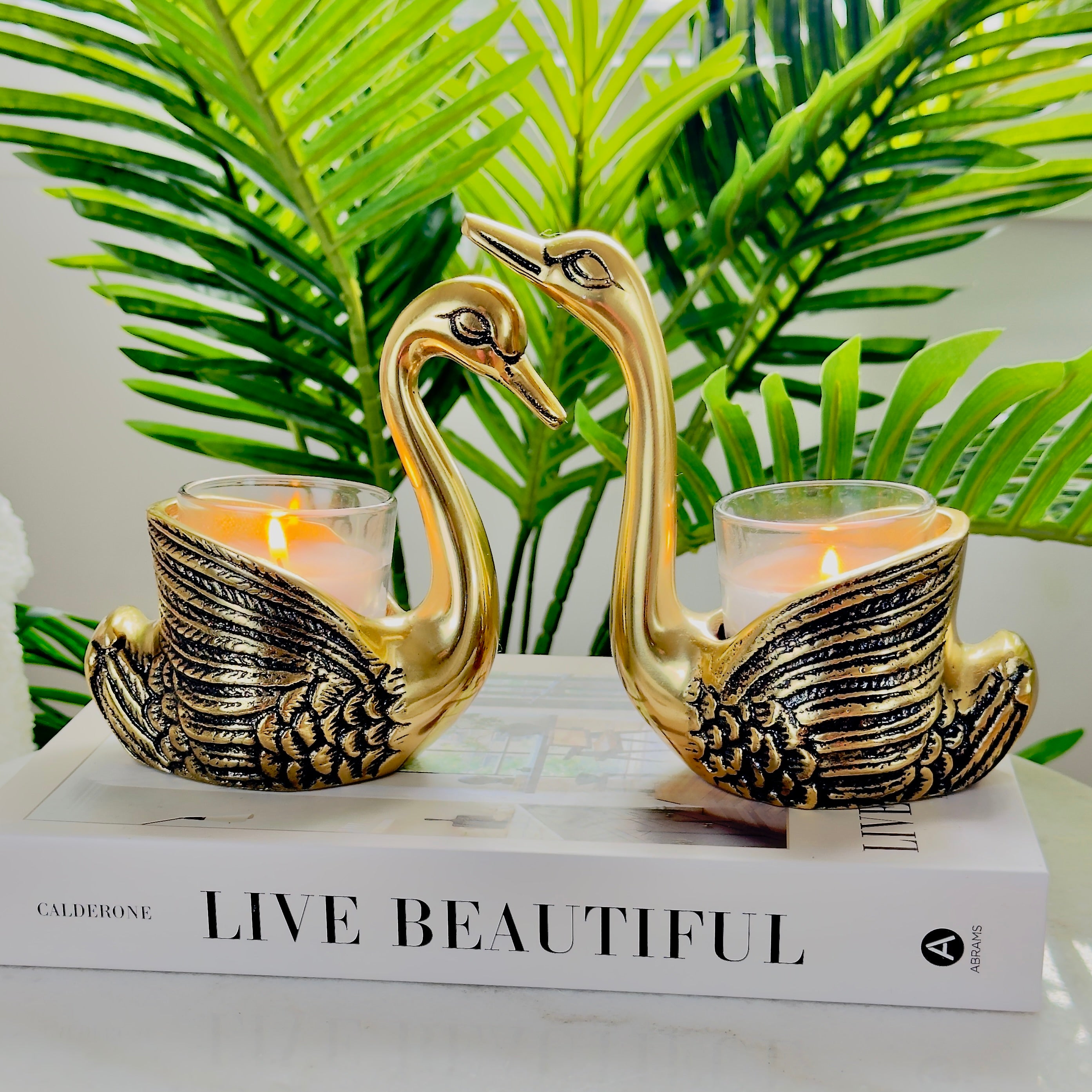 Product image of the Swan Figurine Candle Holder Pair in Gold from Indian Impressions, showcasing two intricately crafted swan-shaped candle holders with a polished gold finish. Ideal for holding candles, this elegant pair is perfect for Vastu, home décor, festive occasions, or gifting, adding sophistication and charm to any space.