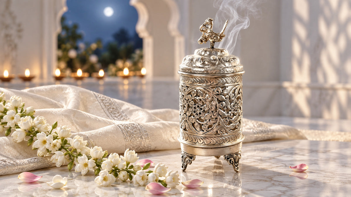 German silver peacock dhuna with incense smoke beside jasmine on white marble