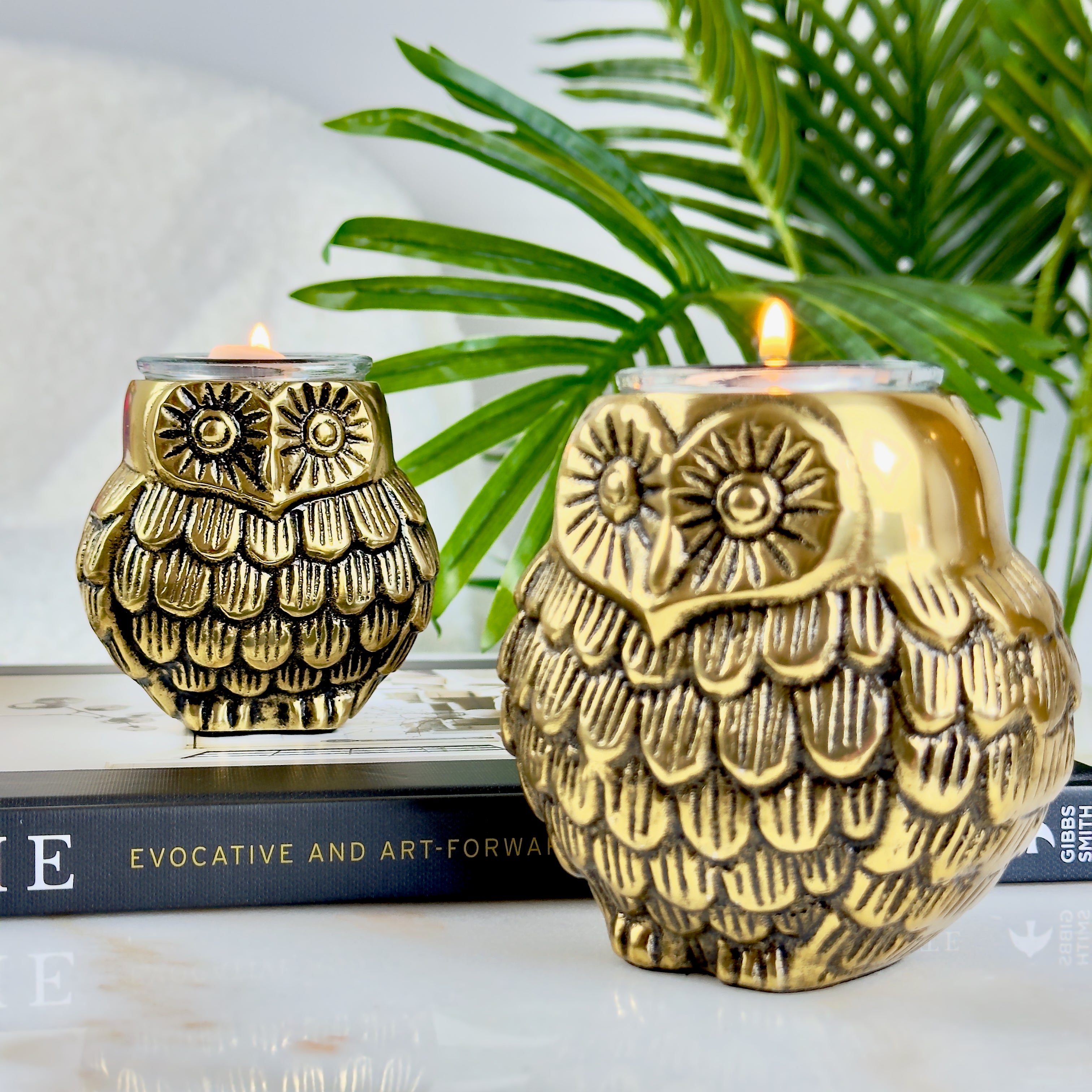 Product image of the Owl Figurine Pair Tea light Holder with Antique Brass Finish from Indian Impressions, featuring two intricately designed owl statues with detailed craftsmanship. Symbolizing wisdom and protection, these figurines are ideal for Vastu, home décor, or gifting, adding a touch of charm and positive energy to any space.