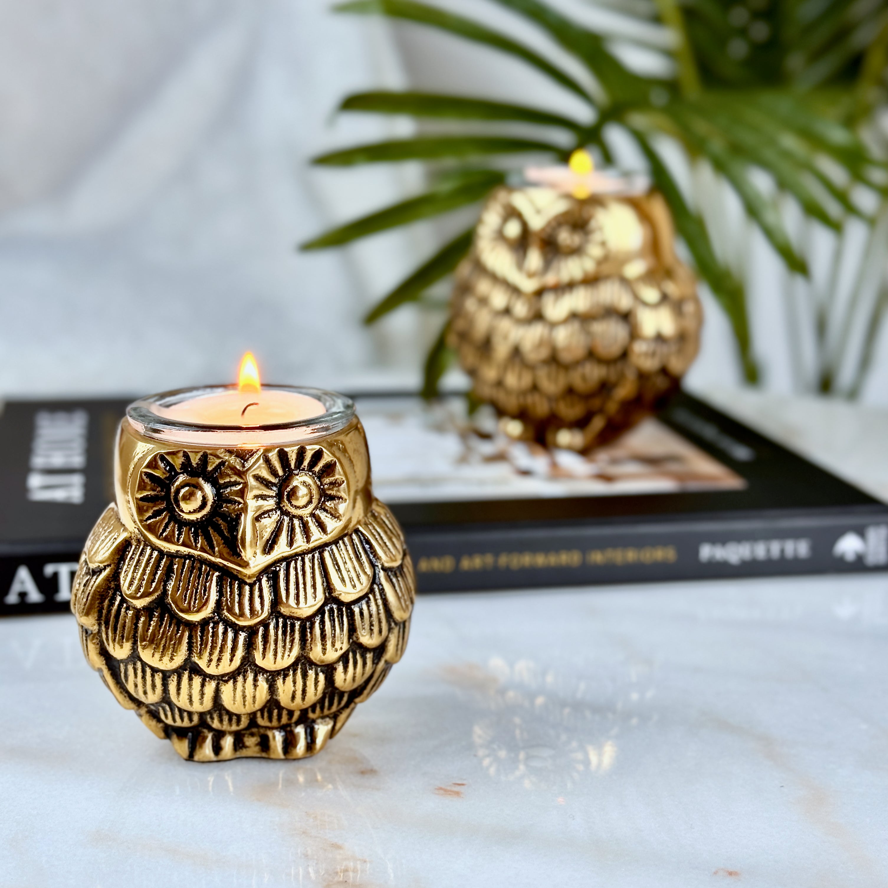 Product image of the Owl Figurine Pair Tea light Holder with Antique Brass Finish from Indian Impressions, featuring two intricately designed owl statues with detailed craftsmanship. Symbolizing wisdom and protection, these figurines are ideal for Vastu, home décor, or gifting, adding a touch of charm and positive energy to any space.