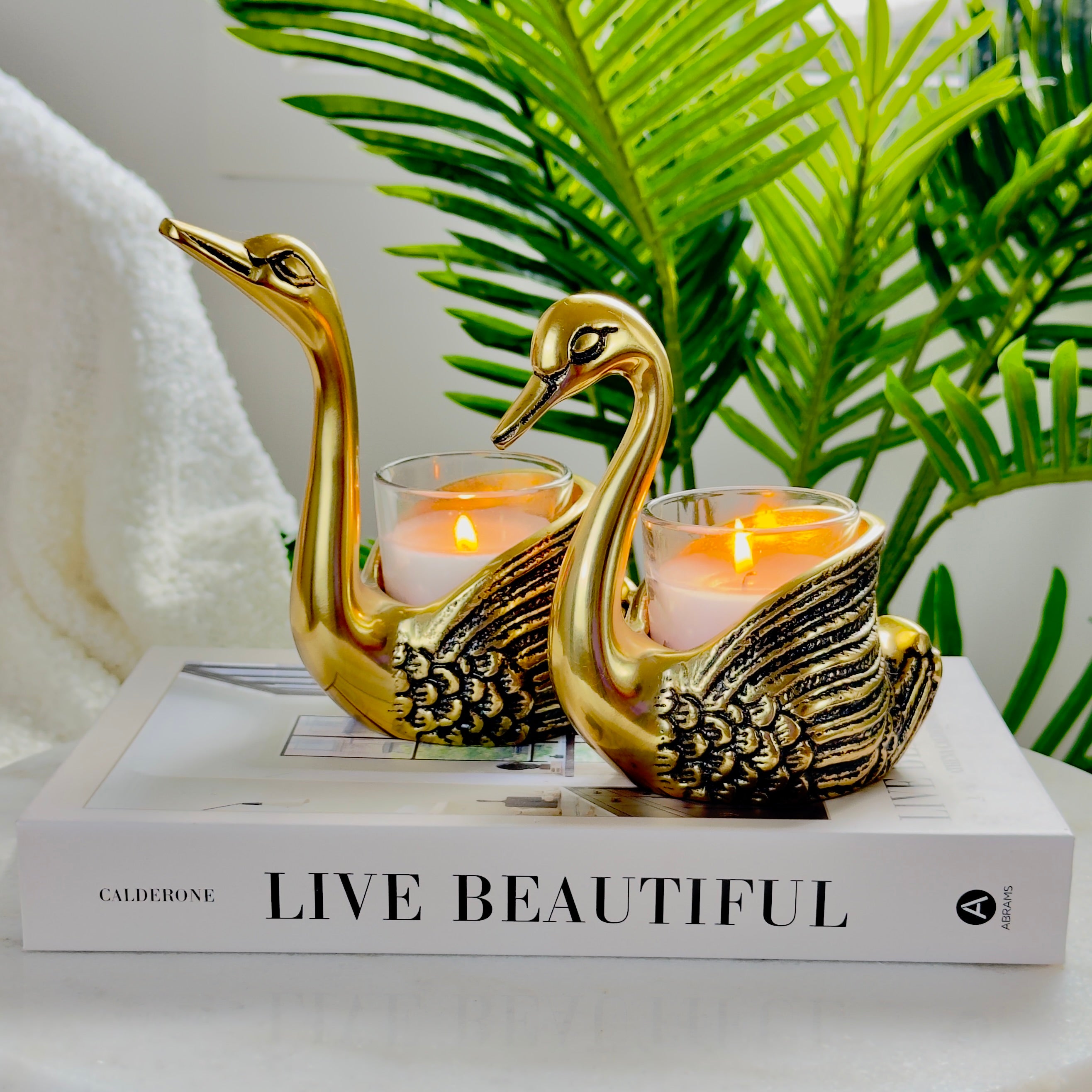 Product image of the Swan Figurine Candle Holder Pair in Gold from Indian Impressions, showcasing two intricately crafted swan-shaped candle holders with a polished gold finish. Ideal for holding candles, this elegant pair is perfect for Vastu, home décor, festive occasions, or gifting, adding sophistication and charm to any space.