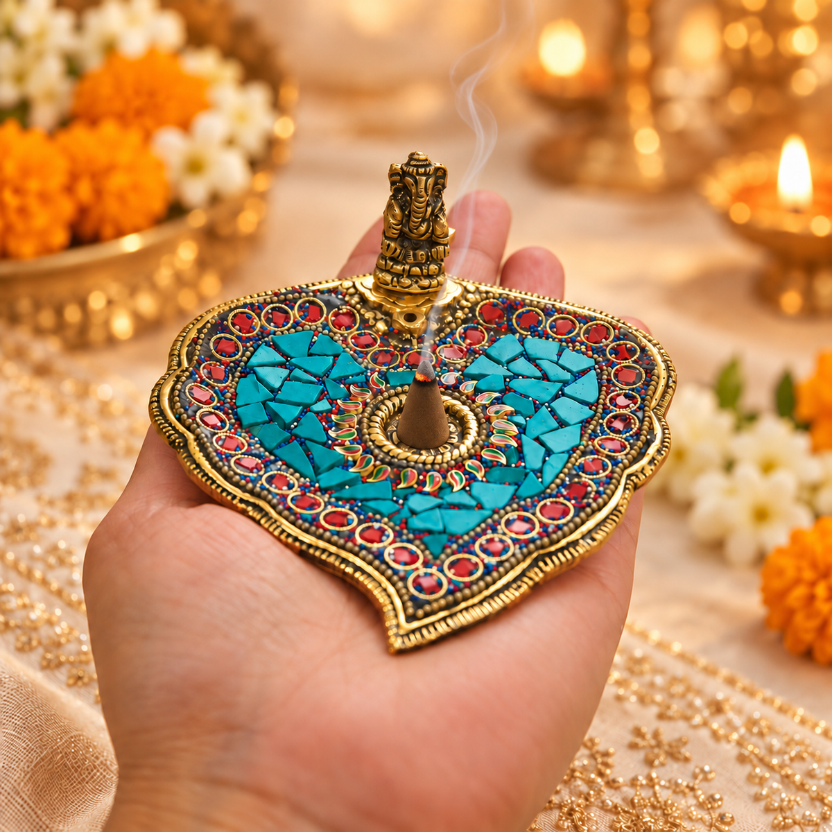Handheld Ganesha paan leaf incense holder with a burning dhoop cone and gentle smoke in a festive setting