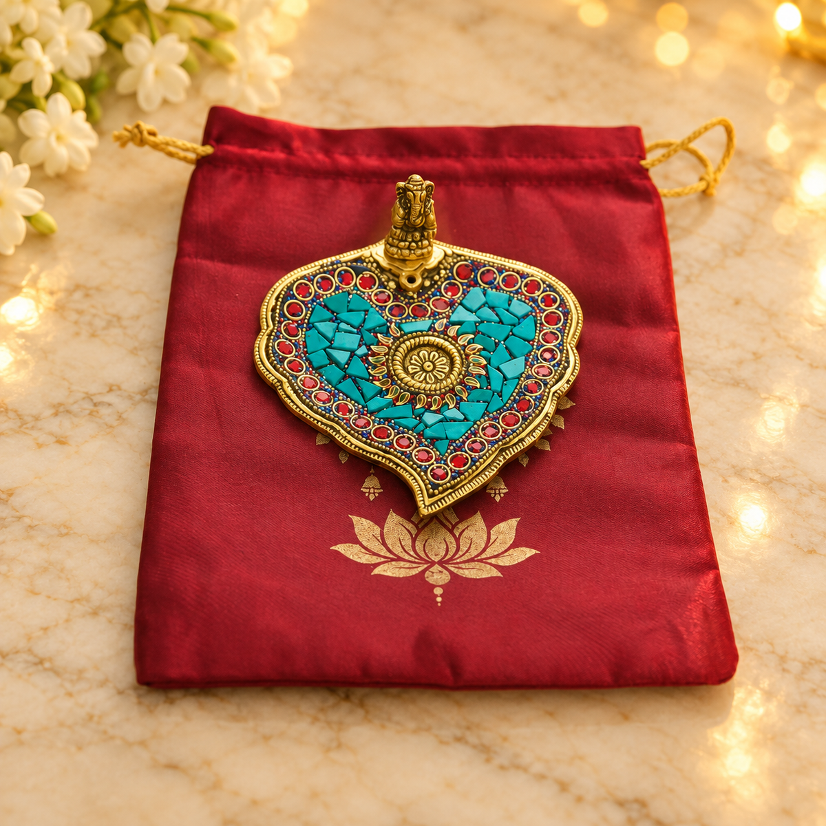 Studded Ganesha incense holder on included burgundy potli bag with festive flowers